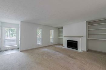 A living room with a fireplace and built-in bookshelves.